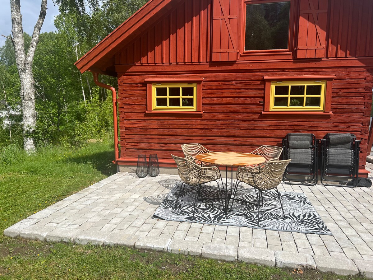 Cottage with lake, dock & boat, open landscape & fields.